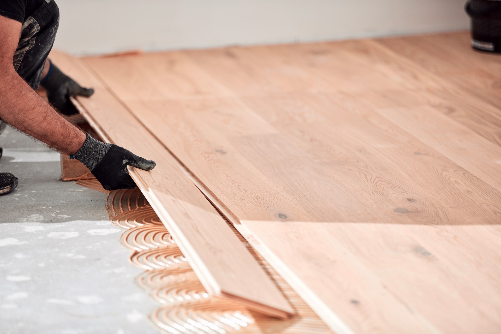 Professional handyman installing laminate flooring in a new apartment.